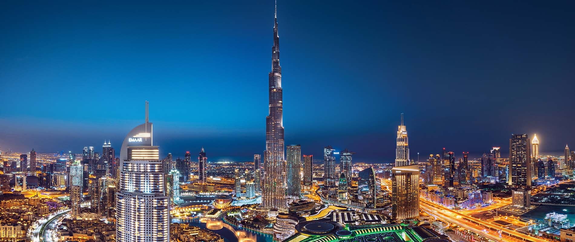 Nighttime cityscape with Burj Khalifa and skyscrapers.