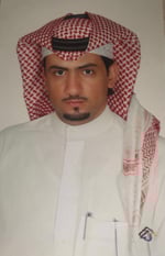 Man in white thobe and keffiyeh against off-white background.