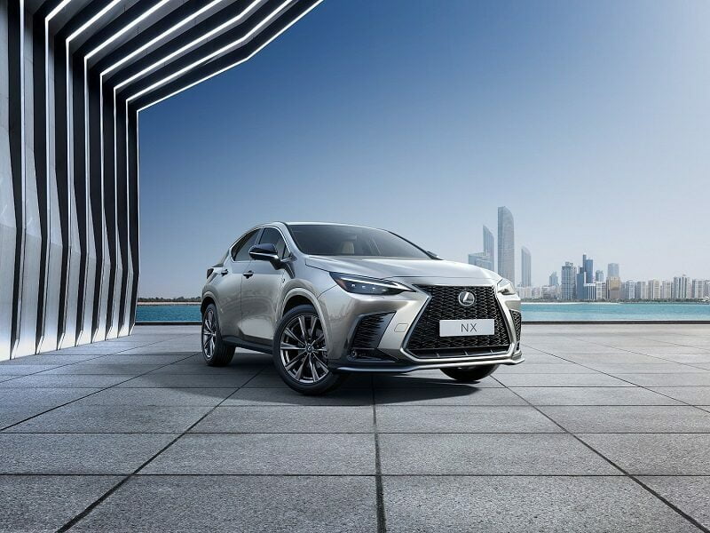 Silver Lexus NX SUV near modern architecture.