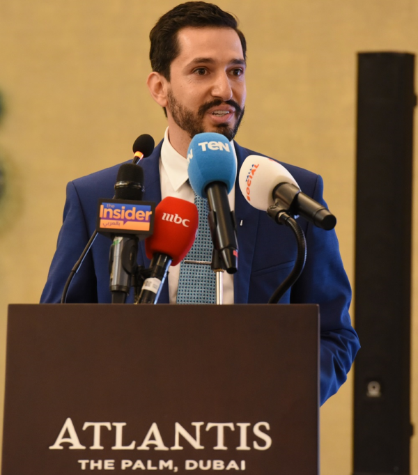 Man speaking at a podium reading 