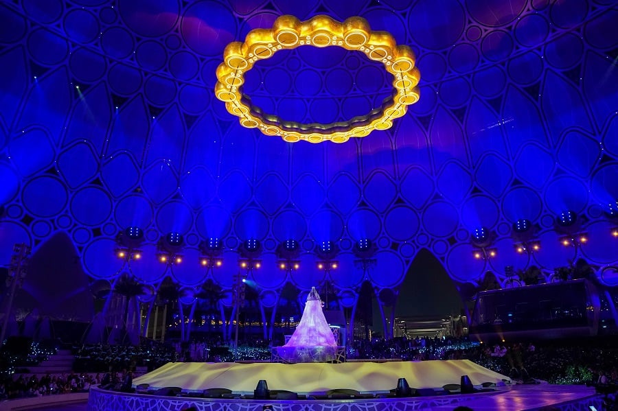 Illuminated dress on stage at outdoor nighttime event.