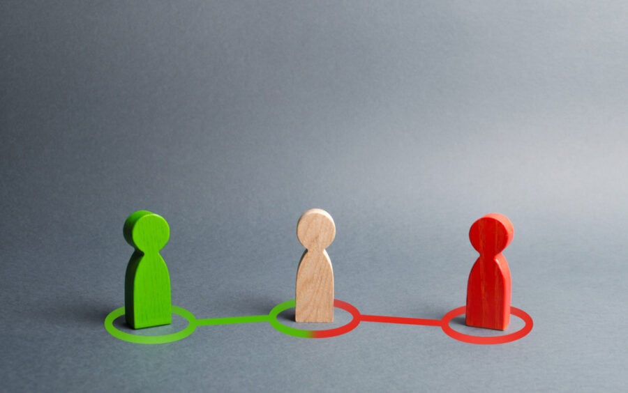 Three colored wooden figures connected by corresponding lines on a gray surface.