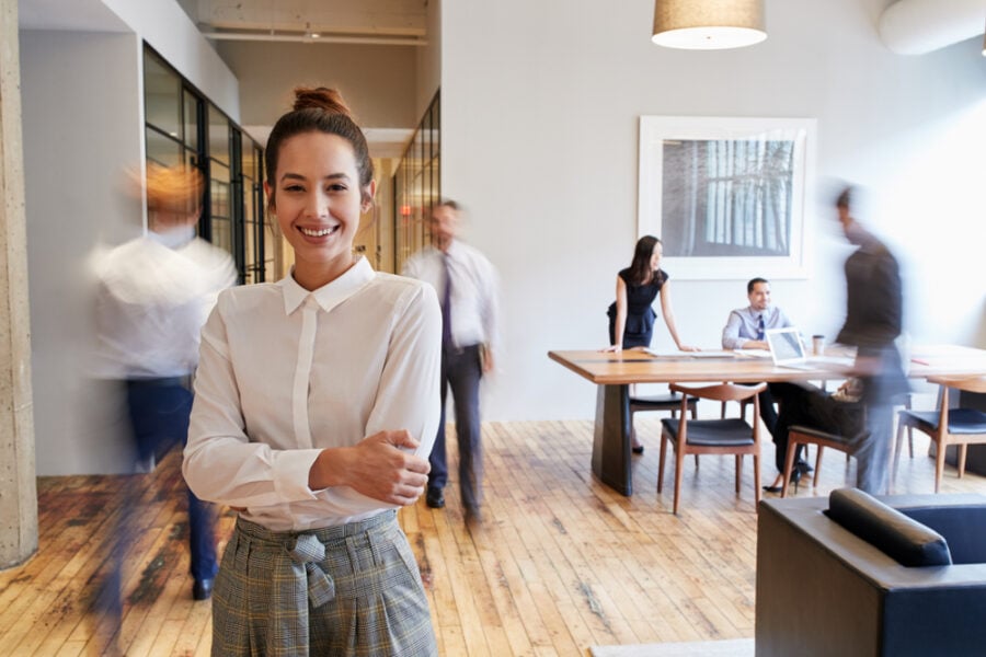 Woman with crossed arms in a modern office.
