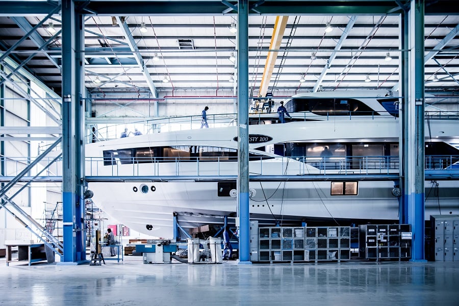 Yacht under construction inside an industrial building.