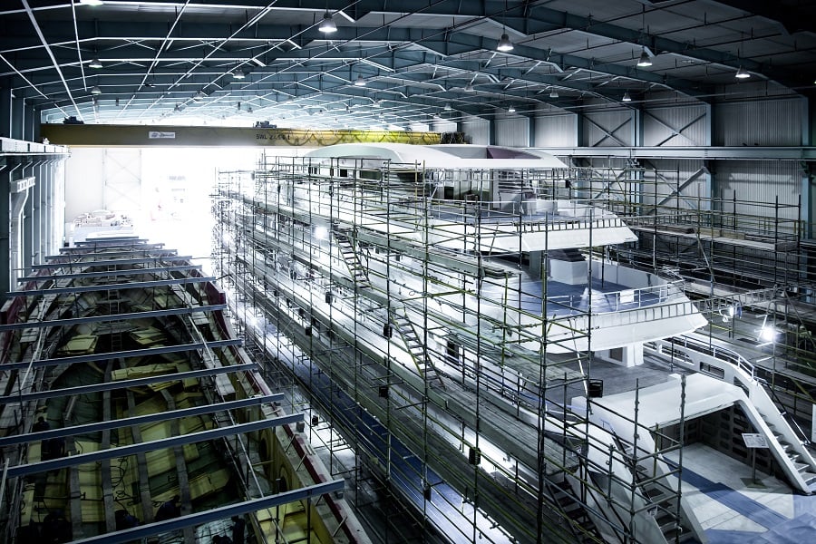 Yacht under construction in a spacious hangar.