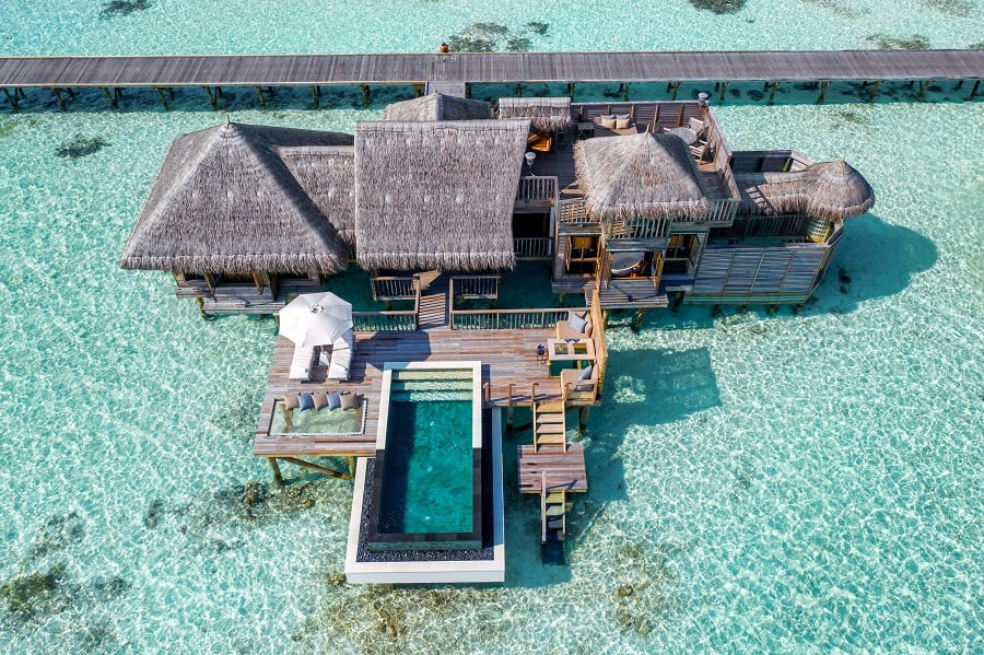 Water villa on stilts over turquoise water with a private pool.