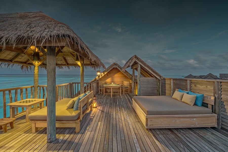 Wooden structures on a deck overlooking the ocean at dusk.