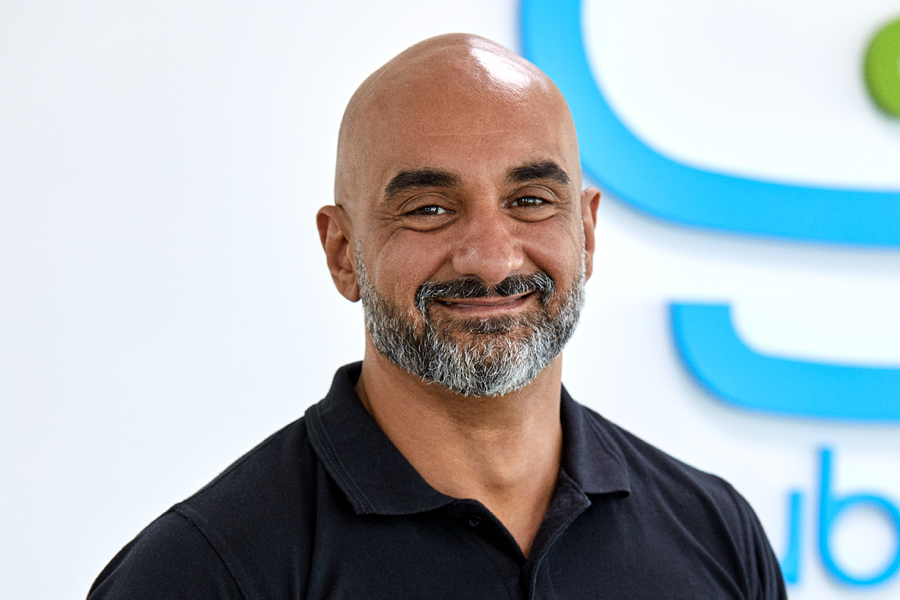 Smiling bald man with a blue background logo.