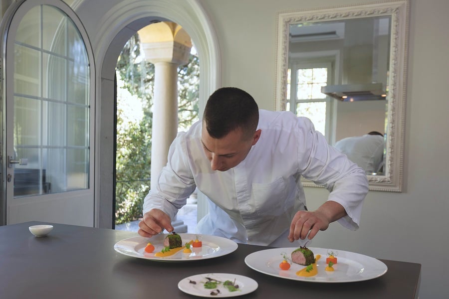 Chef plating dishes in an upscale kitchen.