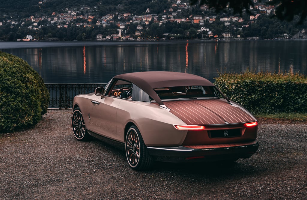 Rolls-Royce Boat Tail parked by lake at dusk.