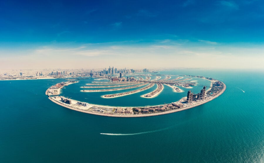 Artificial palm tree-shaped island with buildings and city skyline.