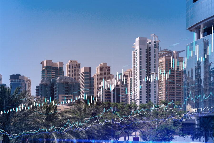 Cityscape with stock market graphs overlaying high-rise buildings.