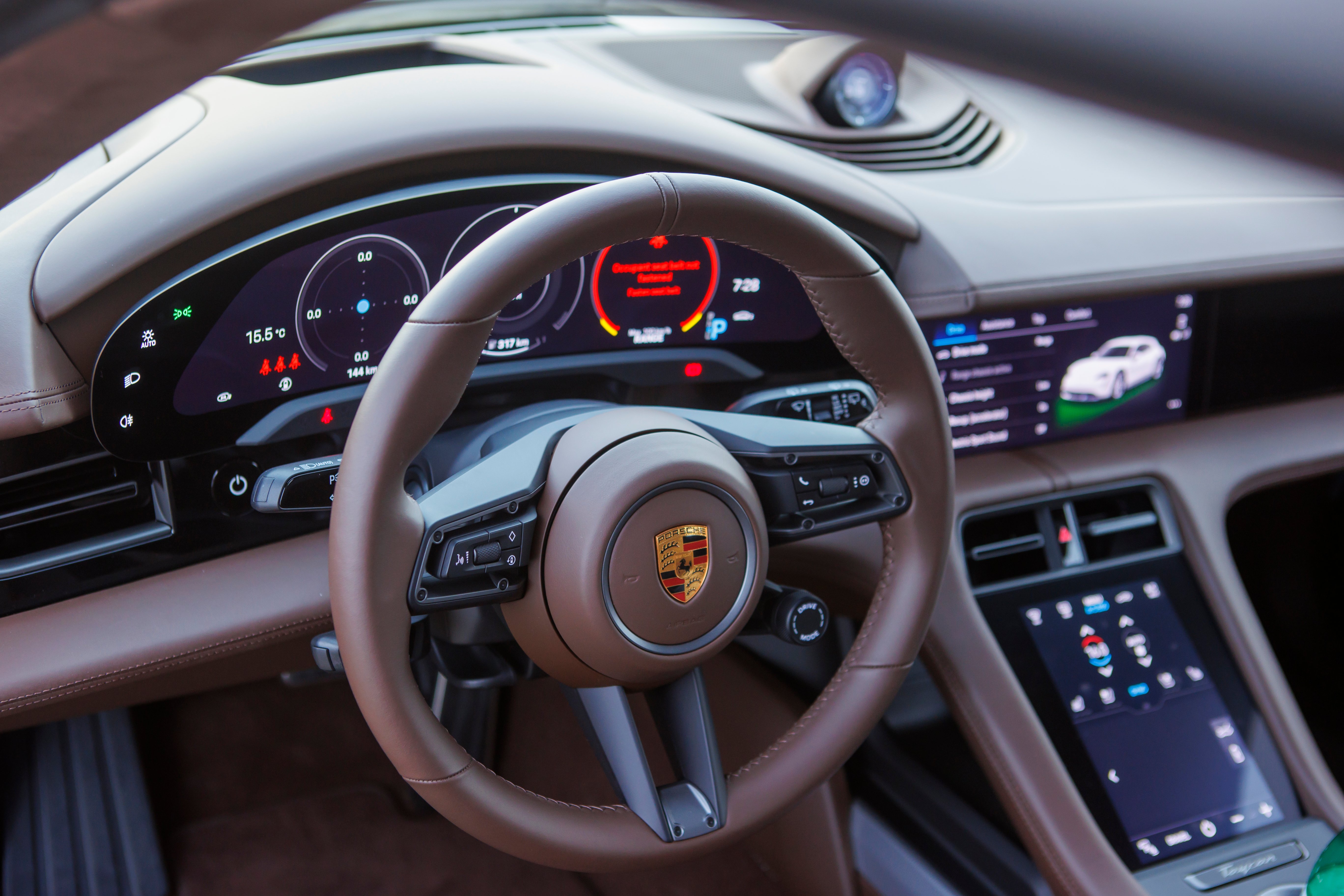 Brown leather steering wheel in a modern car interior.