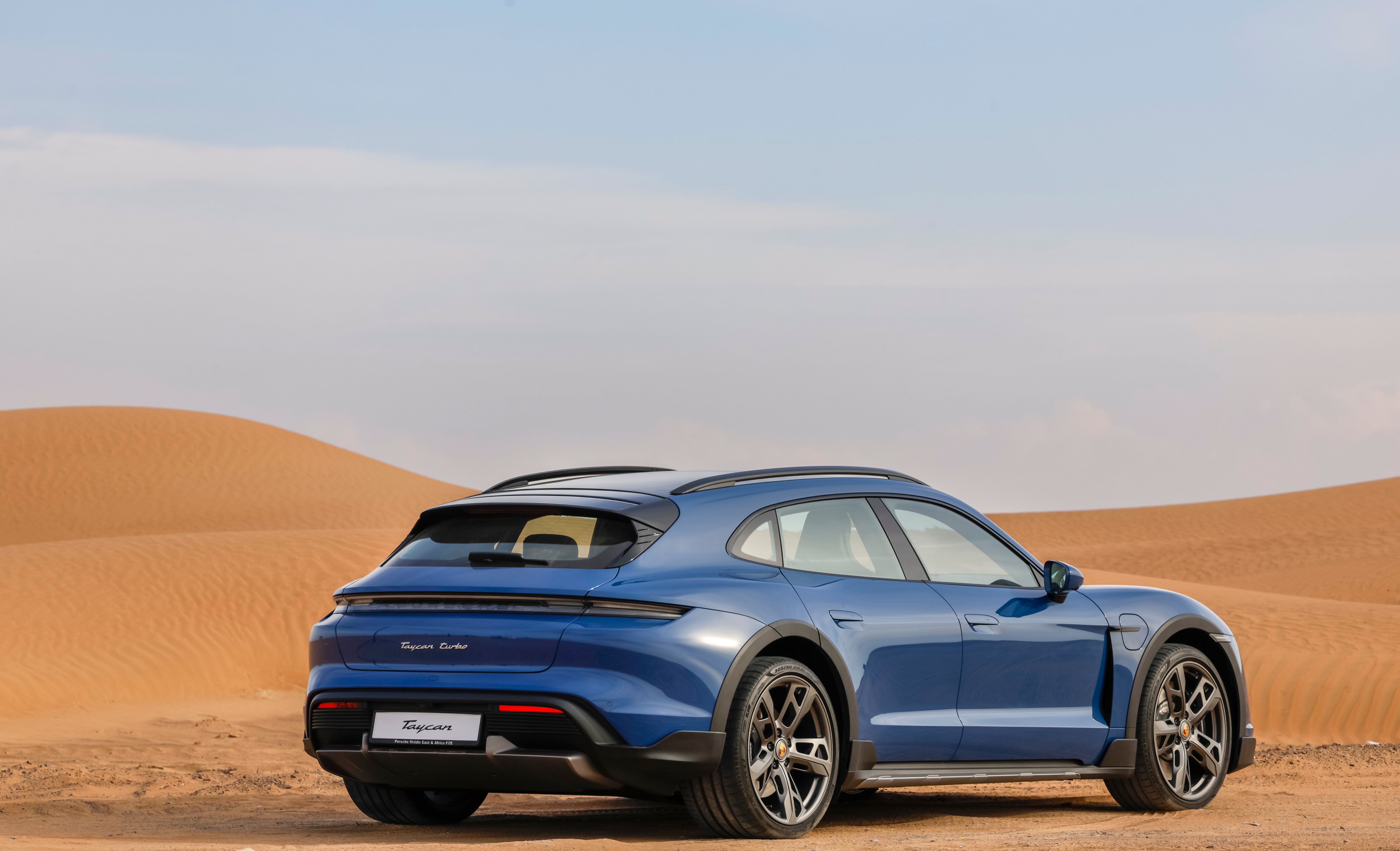 Blue Porsche Taycan Cross Turismo in the desert.