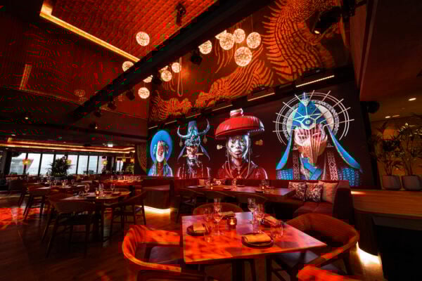 Restaurant interior with Asian-inspired mural and red-toned ambiance.
