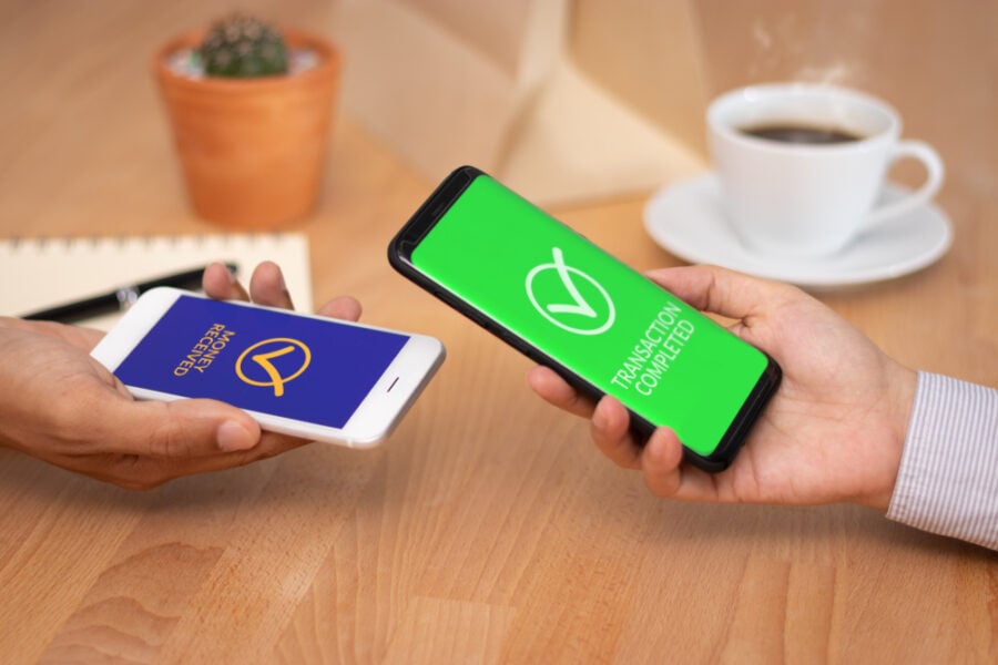 Two smartphones exchanging transaction completion messages.
