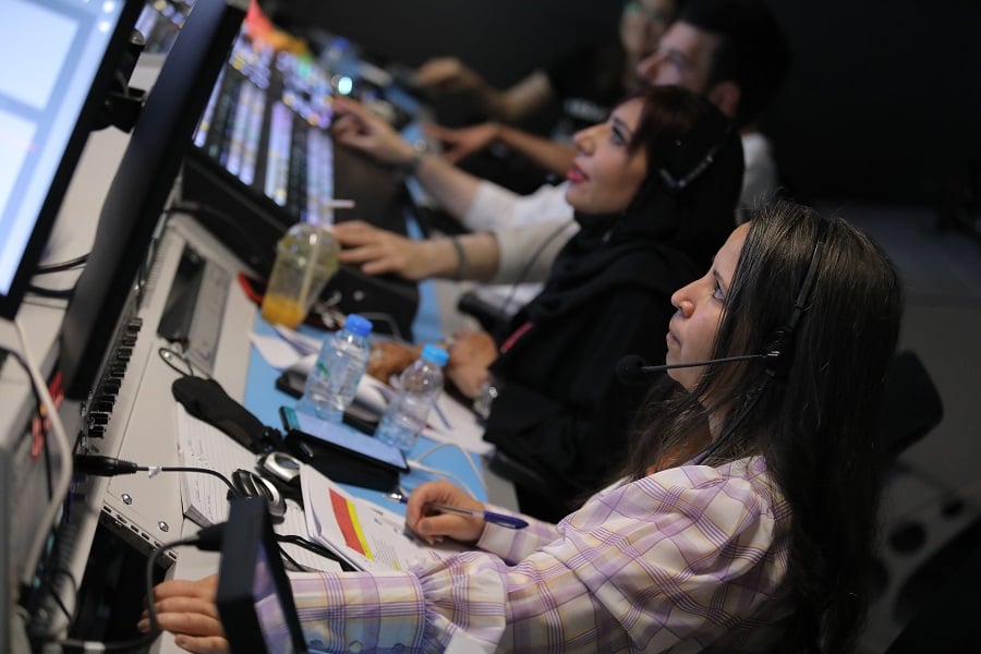 Woman with a headset operating a video control board.