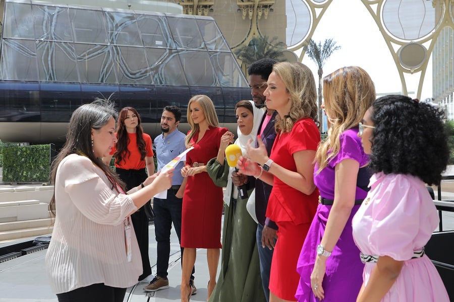 Woman handing a document to a group during a media event.