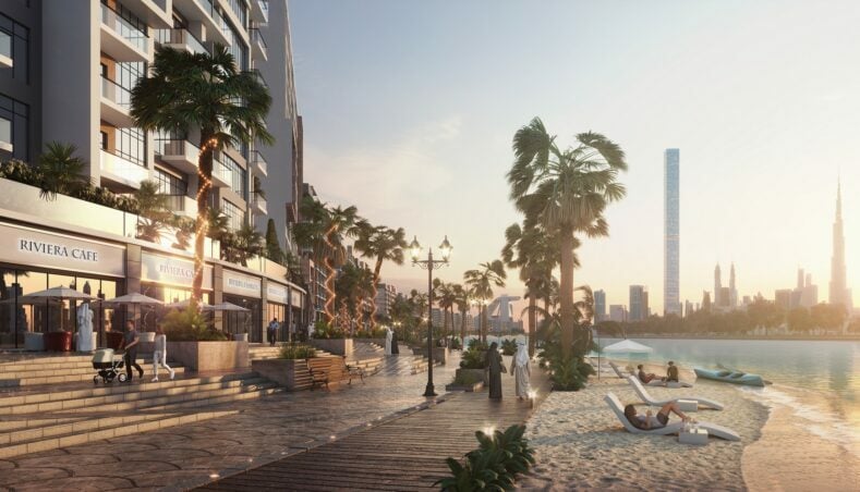 Promenade by the beach at sunset with cityscape backdrop.