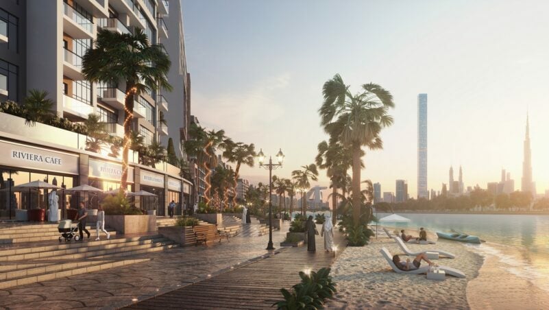 Waterfront promenade with Riviera Cafe and beachgoers at sunset.