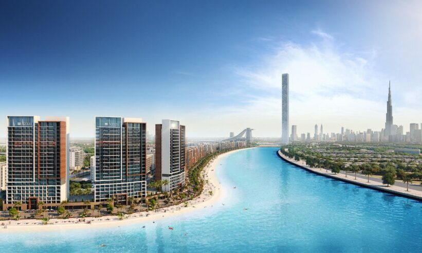 High-rise buildings on sandy beach with cityscape in background.