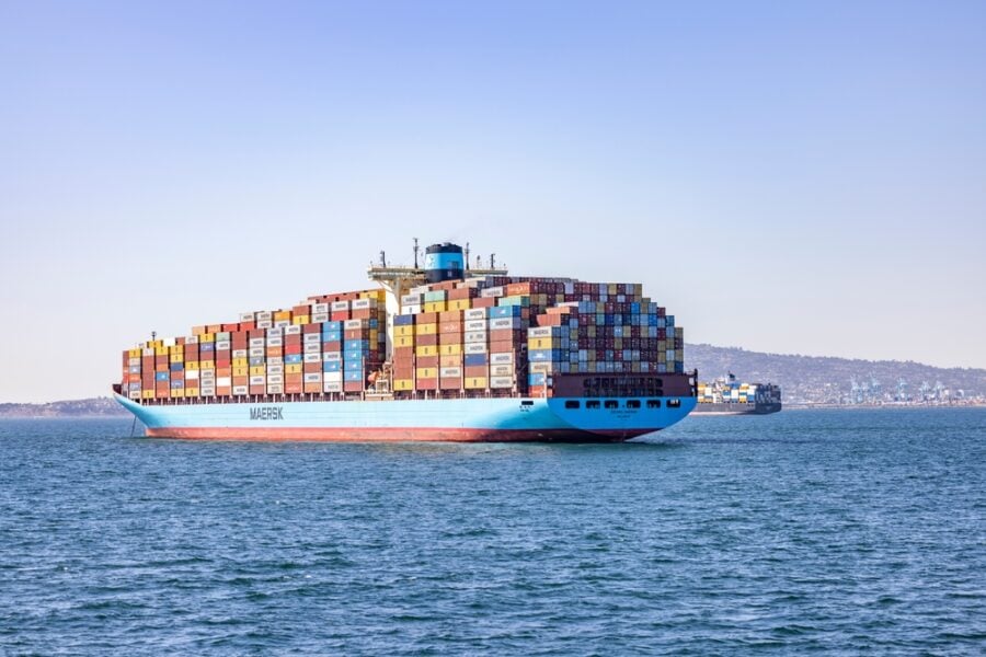 Container ship labeled "MAERSK" sailing across calm ocean.