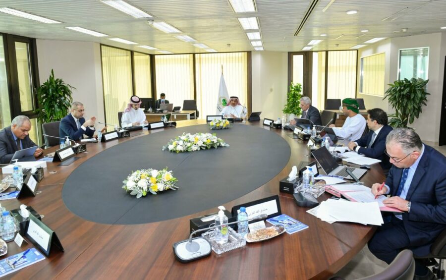 Group of men in suits around a table in a modern office.