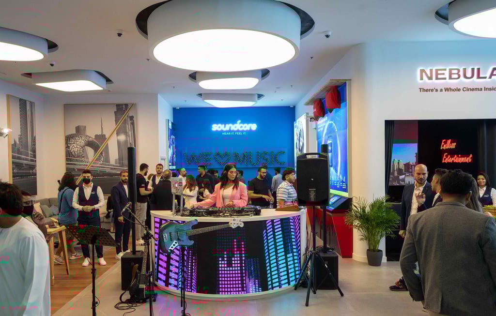 DJ performing at a vibrant launch event with LED displays.