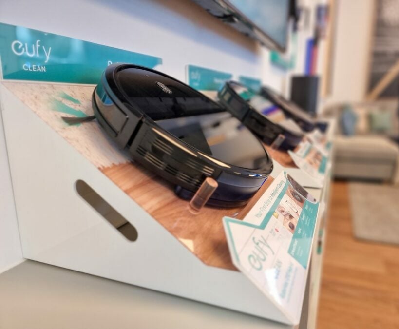 Black robotic vacuum cleaner displayed in a store.