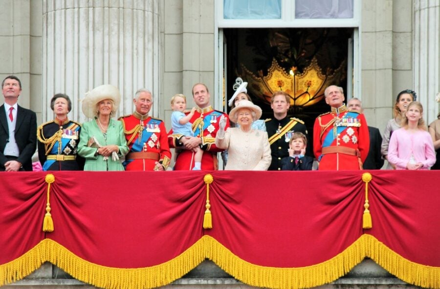 Royal family waving from a palace balcony.