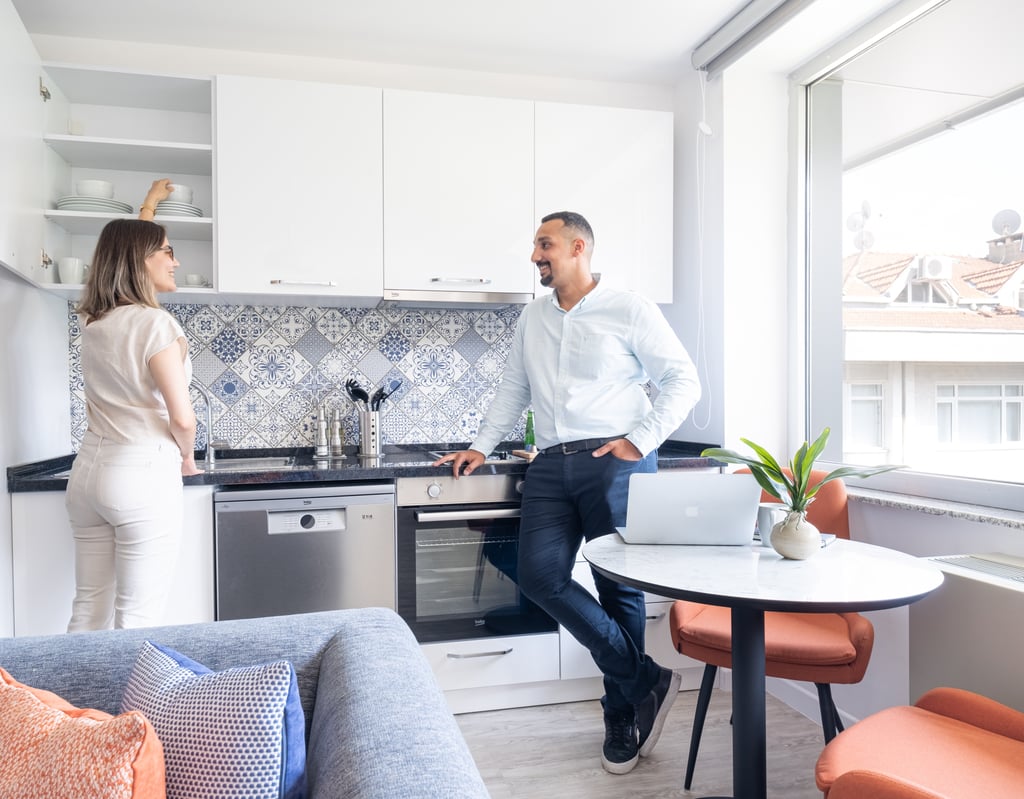 A woman and man interact in a modern kitchen in a bright apartment.