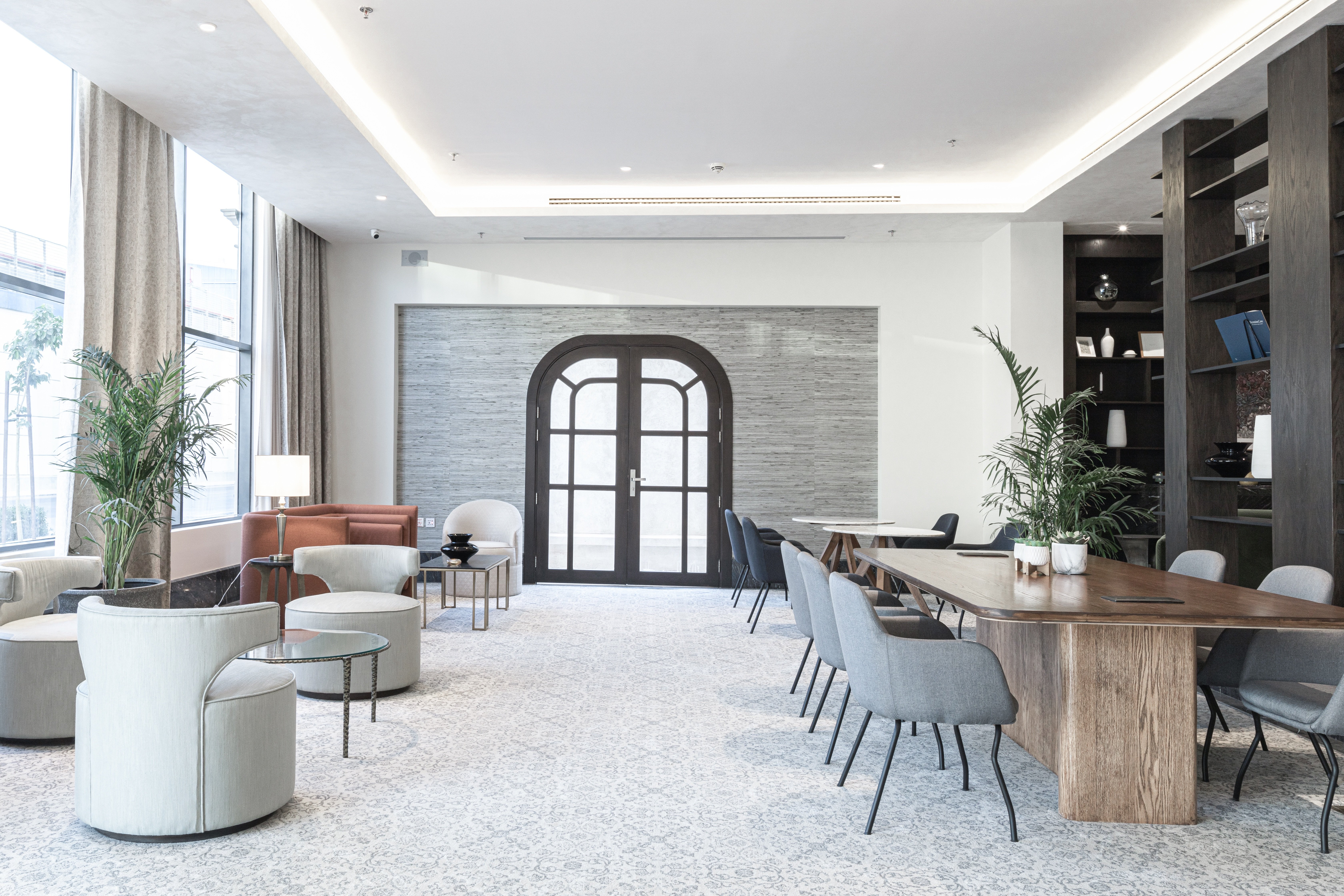 Conference lobby with modern armchairs and large arched door.