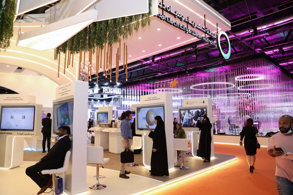 People interacting with energy and water solutions at a trade show.