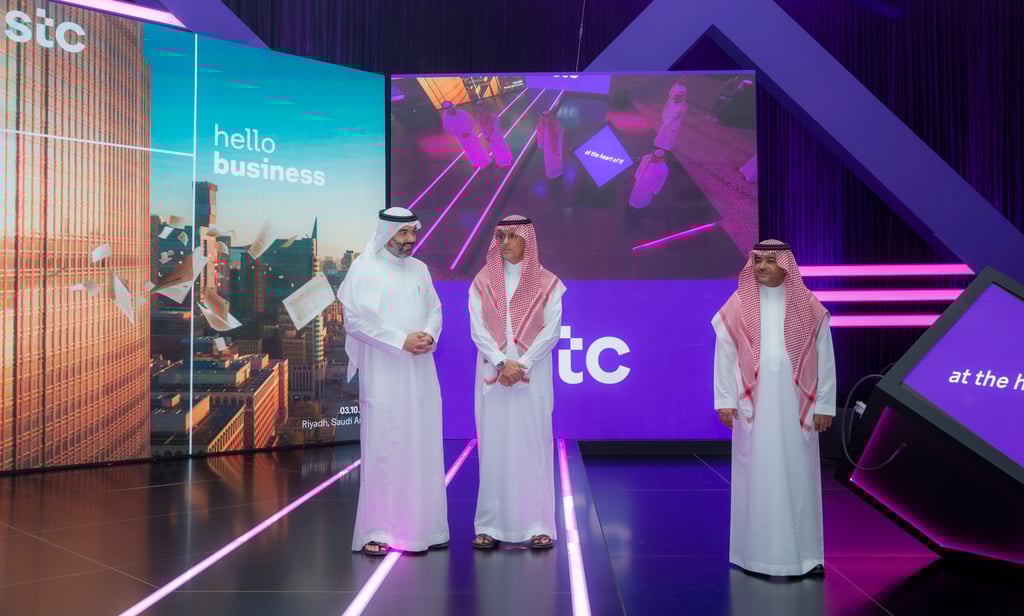 Three men in traditional garb on stage with 
