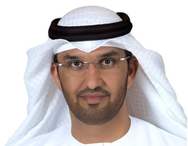 Man in glasses and traditional Arab headdress looks at viewer.
