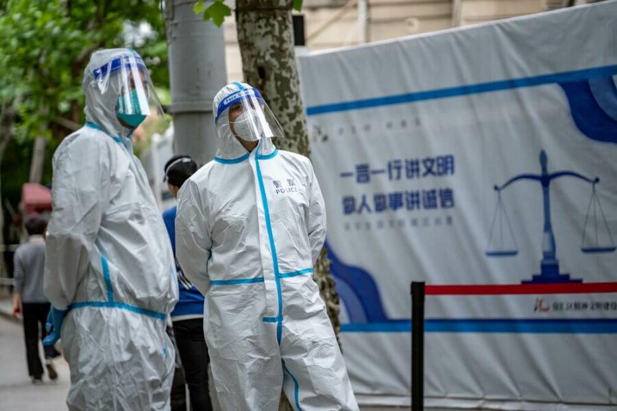 Police officers in PPE standing outside a building with a justice banner.