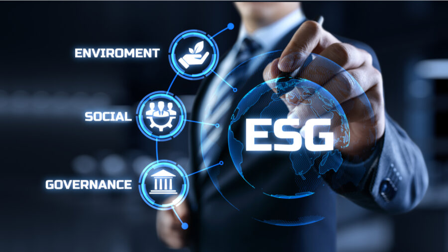 Person interacting with a holographic globe showing ESG icons.
