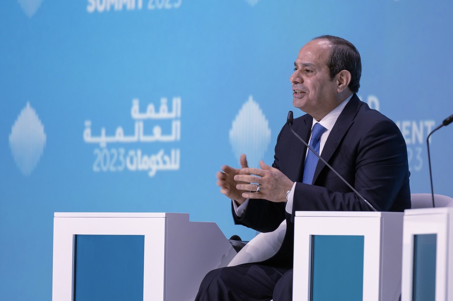 Man in a suit speaking at a podium during a conference.