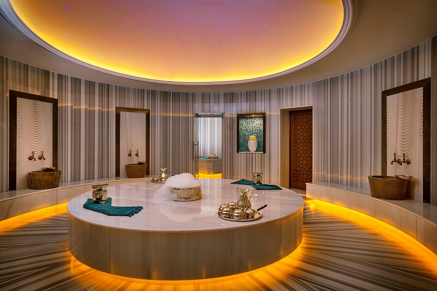 Circular marble bath in a spa with warm lighting.