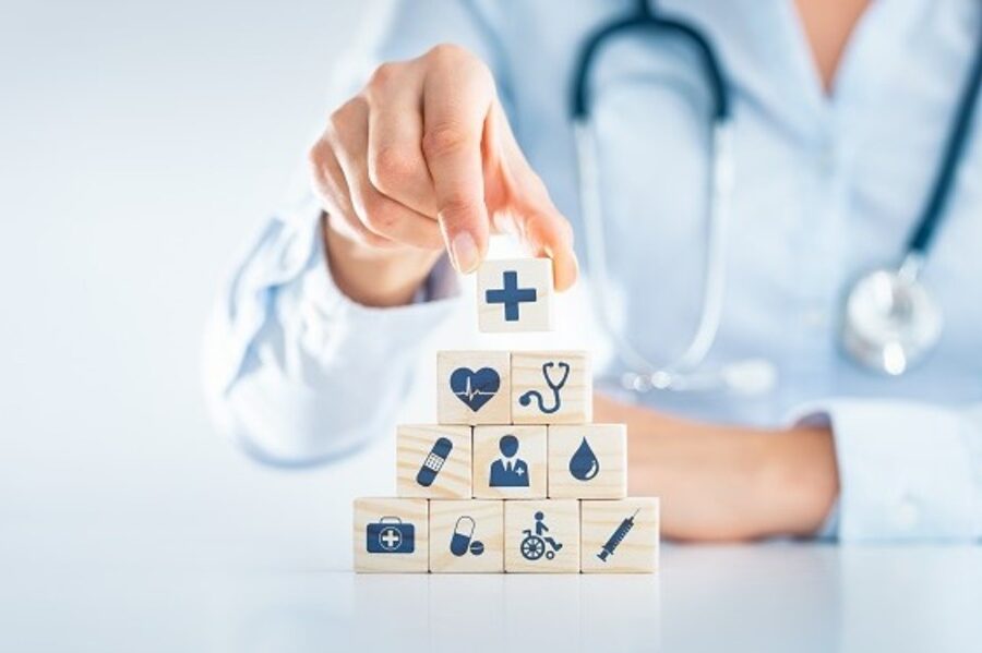 Hand placing a cube with a plus symbol on medical-themed cubes.
