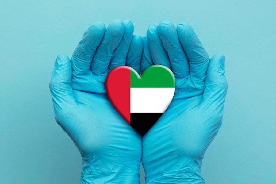 Two hands hold heart-shaped object with UAE flag.