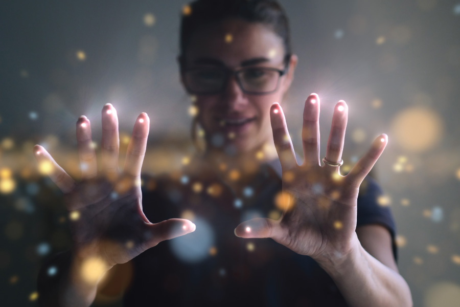 Woman's hands interacting with glowing digital particles.