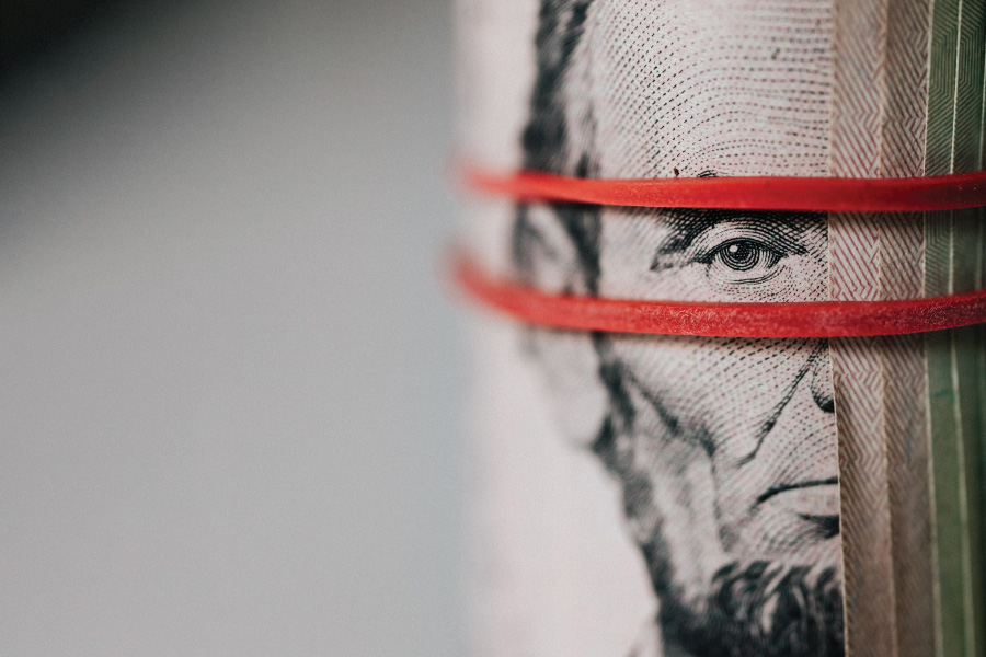 Stack of bills with Abraham Lincoln’s portrait visible.