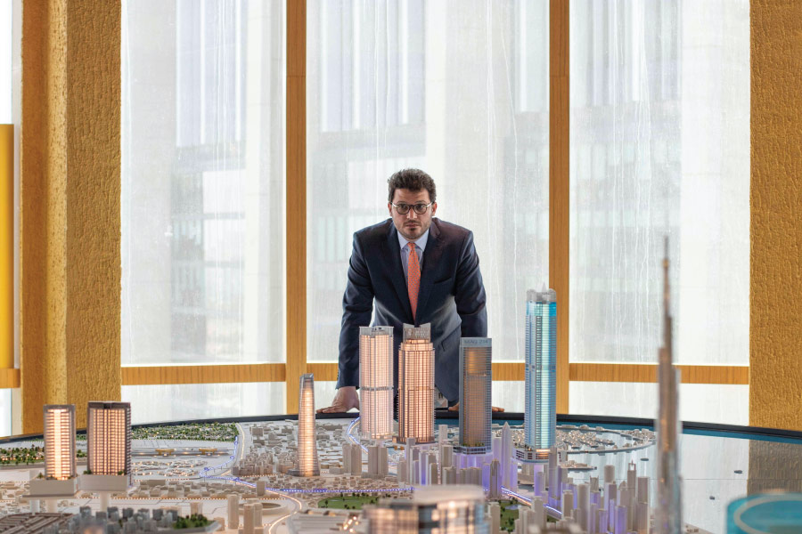 Man examines a cityscape model in a modern office.
