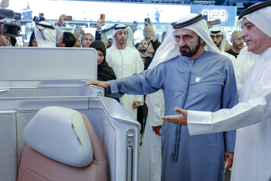 Man inspecting airplane seat design at an airport.