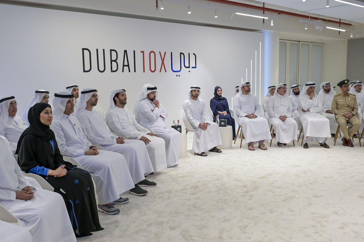 Men and women sitting attentively in a room with "DUBAI 10X" sign visible.