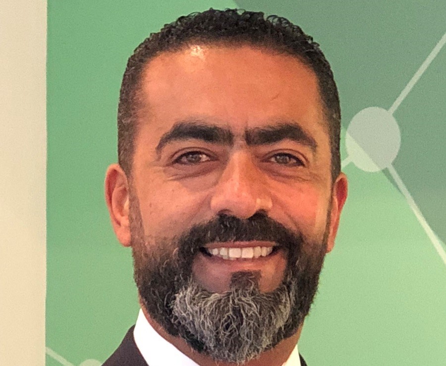 Smiling man with a green background.