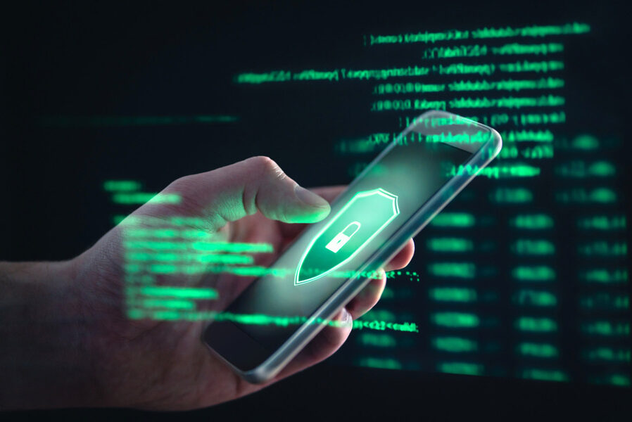 Phone with shield icon over green code background.