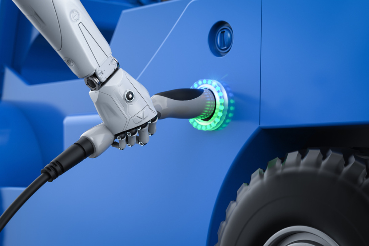 Robotic hand connects a charging cable to a blue vehicle.