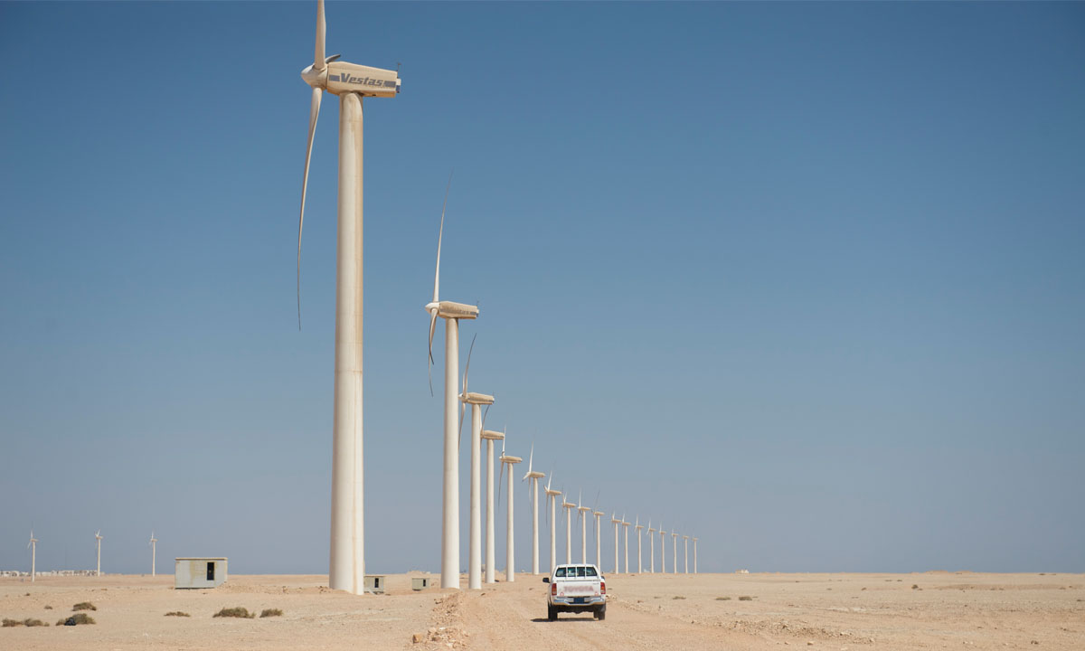 Vestas wind turbines in a desert landscape with a pickup truck.